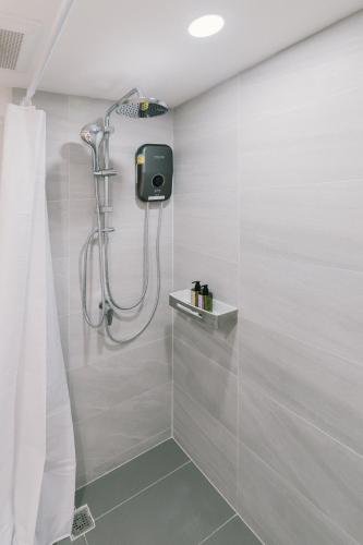 a shower with a shower head in a bathroom at B Innspire Hotel in Chiang Mai