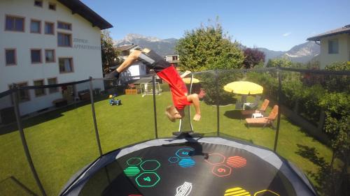 a man is doing a trick on a trampoline at Pension Alpina in Reith im Alpbachtal