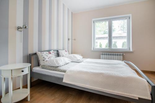 a small bedroom with a bed and a window at Apartament pod Żaglem z Widokiem na Jezioro, Oczy Mazur in Giżycko