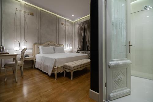 une chambre avec un lit, une table et un bureau dans l'établissement Trésor Art Boutique Hotel, à Korçë