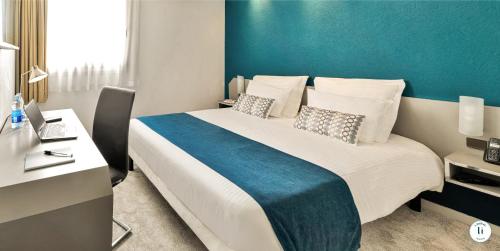 a bedroom with a large bed with a blue wall at L'Initial in Toulouse