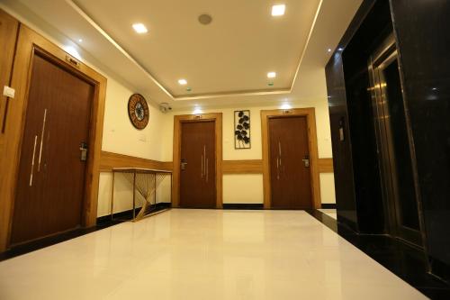 an empty hallway with two doors and a hallwayngth at Mehar Inn Hotel in Kāraikkudi