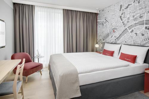 a hotel room with a large bed and a desk at IntercityHotel Hildesheim in Hildesheim
