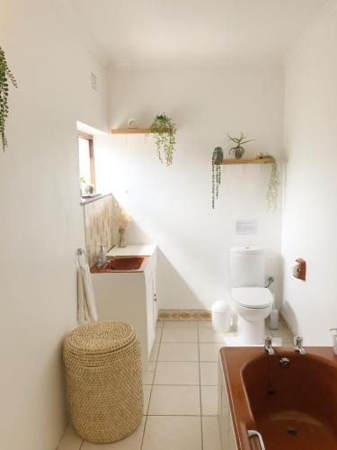 a bathroom with a toilet and a sink and a tub at Rooi Els Sea Cottage in Rooiels