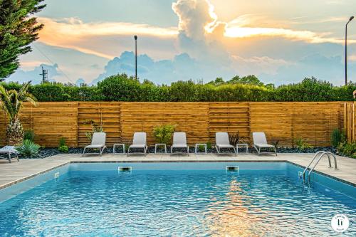 a swimming pool with chairs and a wooden fence at L'Initial in Toulouse