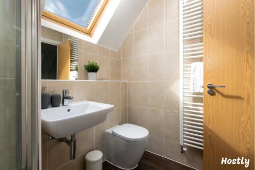 a bathroom with a sink and a toilet and a window at Albatross House - Comfy Home with Parking in Slough