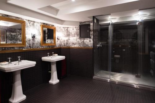 a bathroom with two sinks and a shower at One Devonshire Gardens a Hotel Du Vin in Glasgow