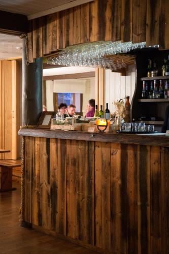 a wooden bar in a restaurant with a group of people at Luomajärven Hevoskievari in Karhoinen