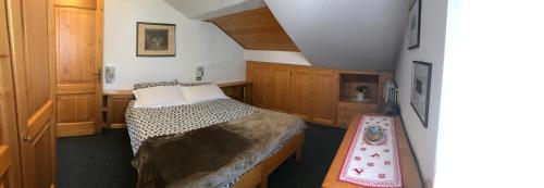 a small bedroom with a bed and a table at Chalet Stelvio in Bormio