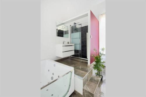 W łazience znajduje się biała wanna i umywalka. w obiekcie La suite de Mont-Vert (Jacuzzi privatif) w mieście Saint-Zacharie
