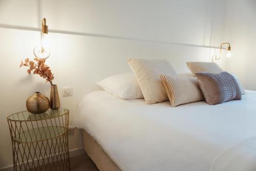 a bedroom with a white bed with pillows on it at Hotel La Chaumette in Privas