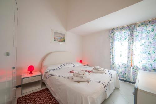 een kleine slaapkamer met een wit bed en een raam bij Casa Piccy in Porto Istana