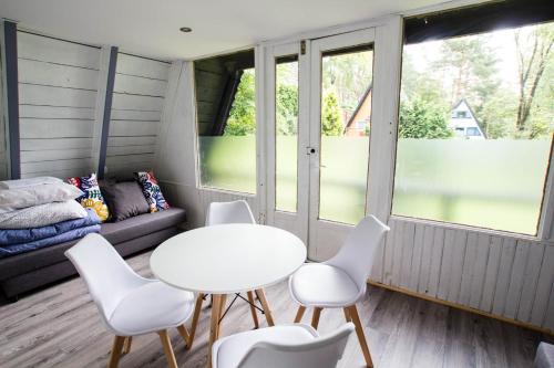 a room with a table and chairs and a couch at Ośrodek Wypoczynkowy AKWA Marina in Nysa