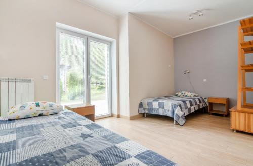 - une chambre avec 2 lits et une fenêtre dans l'établissement Apartament pod Grotem z Widokiem na Jezioro, Oczy Mazur, à Giżycko