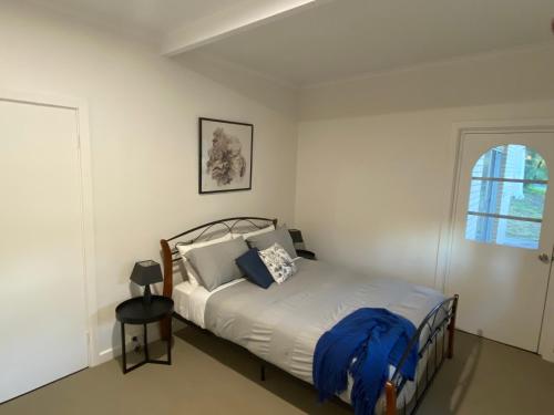 a bedroom with a bed with a blue blanket on it at Panorama B&B in Naracoorte