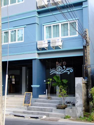a blue building with stairs in front of it at Kata Bai D - SHA Certificate Hotel in Kata Beach