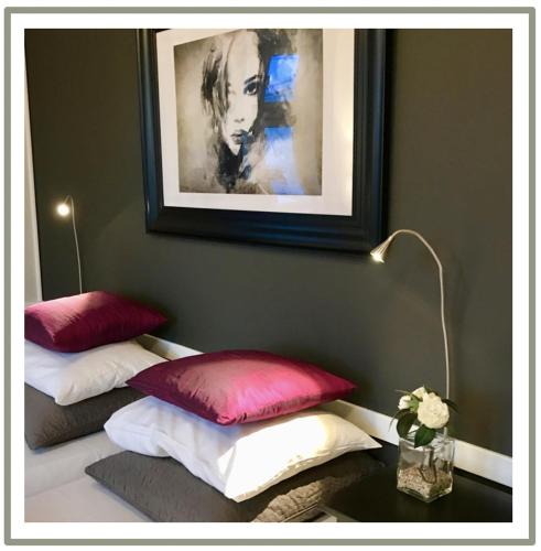 two pillows on a bed with a picture on the wall at Reenskaug Hotel in Drøbak