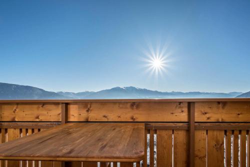 a wooden table on a deck with a view of the mountains at Apartment Dolomitenblick in Mühlbach