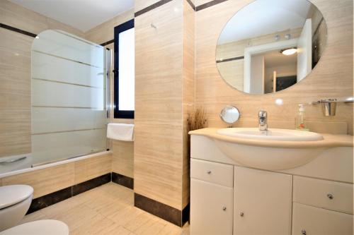 La salle de bains est pourvue d'un lavabo et d'un miroir. dans l'établissement Estepona Port Apartment FLO, à Estepona