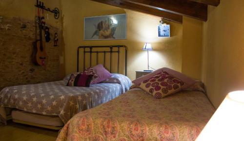 a bedroom with two beds and a guitar on the wall at CASA CASTAÑÉ in Puente de Domingo Flórez