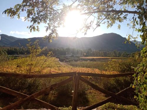a fence in a field with the sun in the background at Sa Perda Arrubia in Cardedu