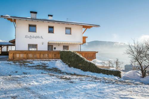 a house with a fence in the snow at Apartment Dolomitenblick in Mühlbach
