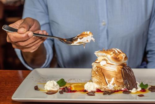 a man is eating a dessert with a spoon at Grand Hotel Tralee in Tralee