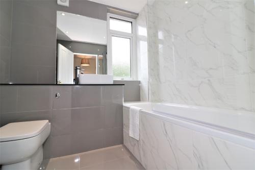 ein Badezimmer mit einer Badewanne, einem WC und einem Waschbecken in der Unterkunft Macintosh lower in Bellshill