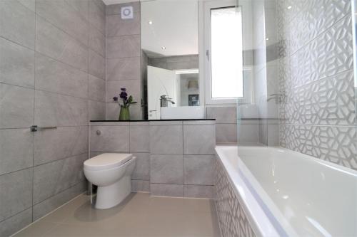 uma casa de banho com um WC, uma banheira e um lavatório. em Macintosh Upper em Bellshill