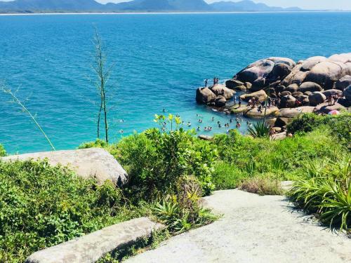 a group of people swimming in a body of water at Nosso Lounge Hostel in Florianópolis