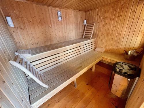 uma vista interior de uma sauna com um banco em Villa 200m2 avec PISCINE chauffée & SPA & sauna & kota-grill em Laval-sur-Vologne