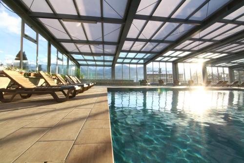 - une piscine avec des chaises longues dans un bâtiment dans l'établissement Cerdanya EcoResort, à Prullans