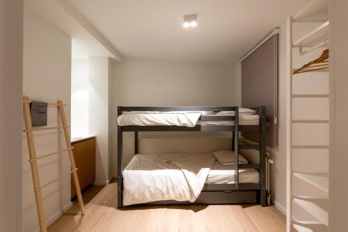 1 Schlafzimmer mit 2 Etagenbetten und einem Schrank in der Unterkunft Modern & spacious apartment near beach in Knokke in Knokke-Heist