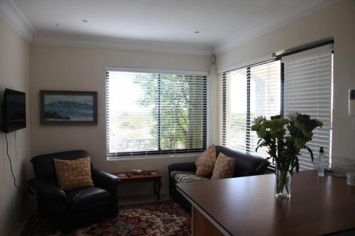 a living room with a couch and a table and two chairs at Mossel is the Gem of Yzerfontein in Yzerfontein