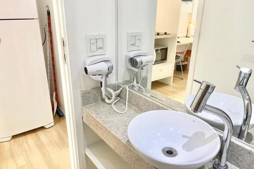 une salle de bain avec un lavabo blanc et un miroir dans l'établissement Lindo ap Augusta 207ua, à São Paulo