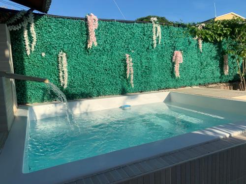 a swimming pool with a green privacy fence at Hotel Luis V Santo Domingo in Santo Domingo