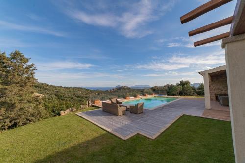 a backyard with a swimming pool and a lawn at Borgo Smeraldo Villas in Arzachena