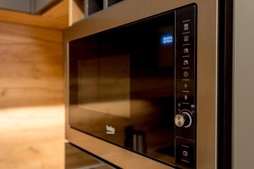 a microwave oven with its door open in a kitchen at Athos Square Apartments in Podgorica