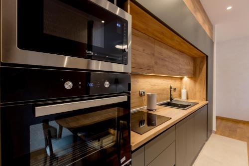 a kitchen with a microwave and a sink at Athos Square Apartments in Podgorica
