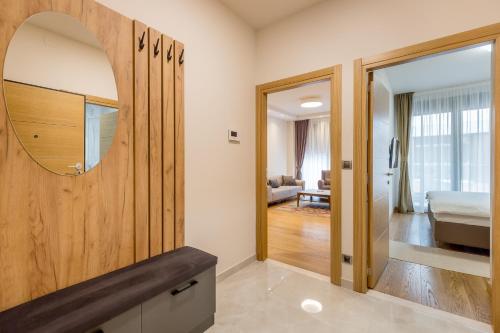 a bathroom with a mirror and a bedroom at Athos Square Apartments in Podgorica