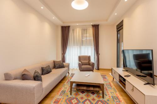 a living room with a couch and a flat screen tv at Athos Square Apartments in Podgorica