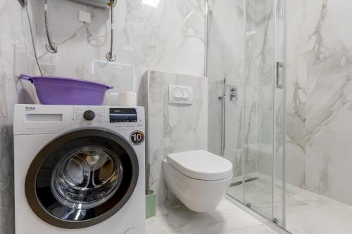 a bathroom with a washing machine and a toilet at Athos Square Apartments in Podgorica