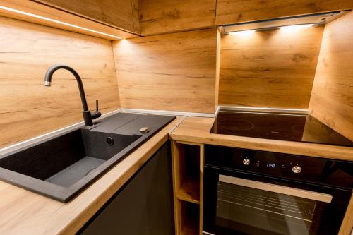 a kitchen with a sink and a stove at Athos Square Apartments in Podgorica