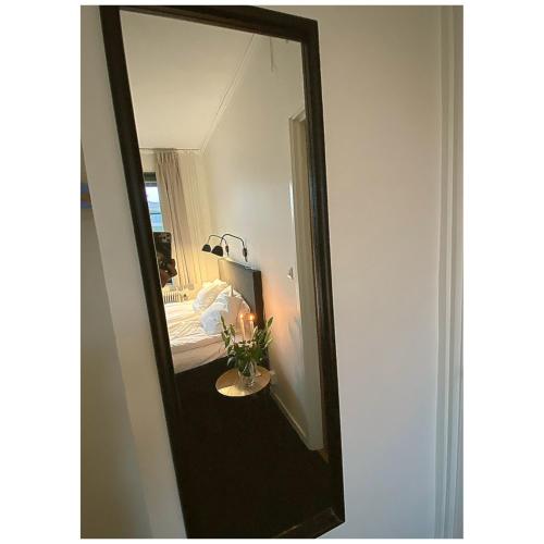 a mirror on a wall next to a bedroom at Hotell Värend in Växjö