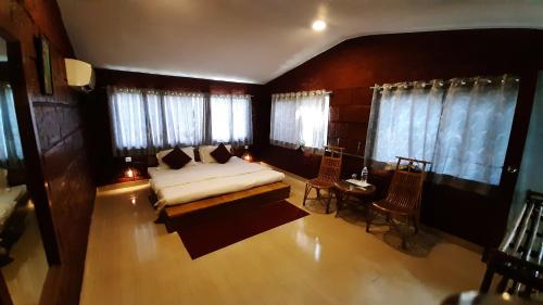 a bedroom with a bed and a table and chairs at Anandvan Holiday Homes, Wai in Wai