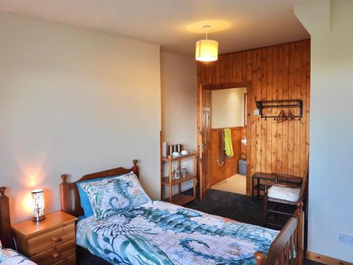 a bedroom with a bed and a table and a chair at Windhaven Camping and B&B in Thurso