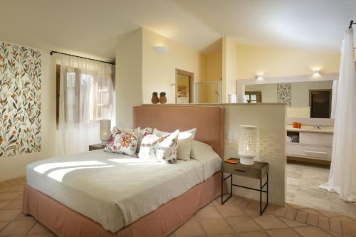 a bedroom with a large bed and a kitchen at Borgo Smeraldo Villas in Arzachena
