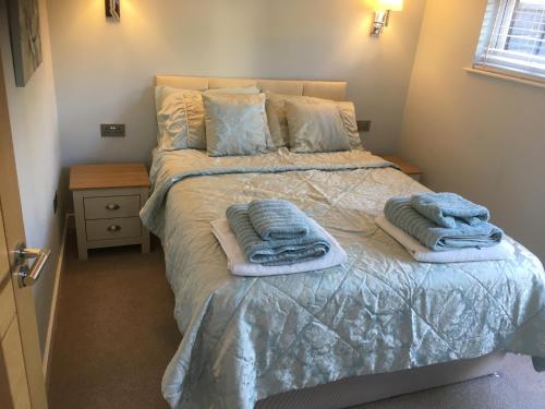 a bedroom with a bed with towels on it at Sunset Retreat Lodge with Hot Tub in Carsethorn