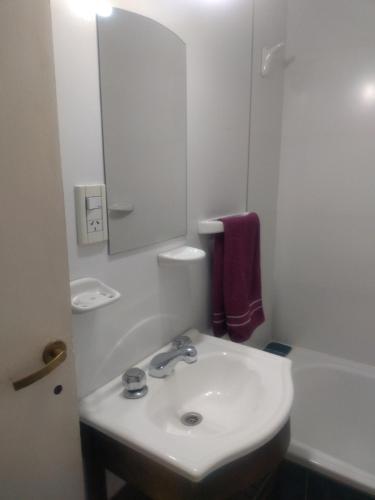 a white bathroom with a sink and a bath tub at Departamento Lemos 678 in Mendoza