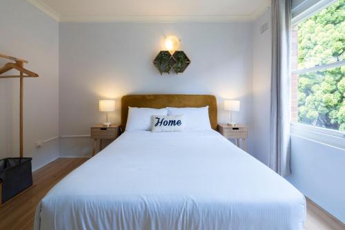 a bedroom with a large white bed with a window at Lotus Stay Manly - Apartment 31G in Sydney